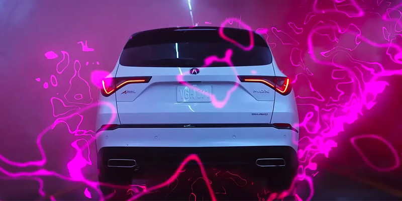A white 2025 Acura MDX SUV with the Acura logo, surrounded by swirling pink patterns in a dimly lit tunnel.