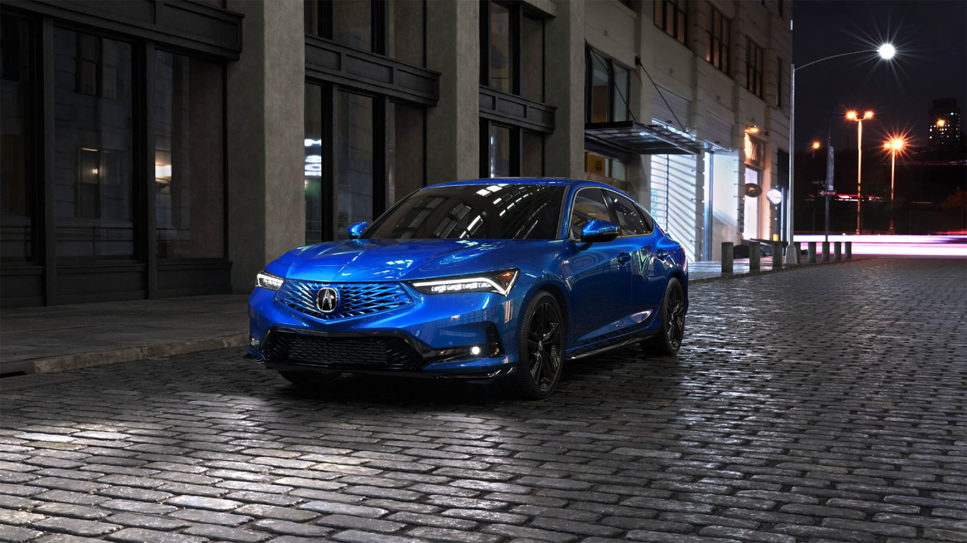 2026 Acura Integra in blue on a cobblestone street at night