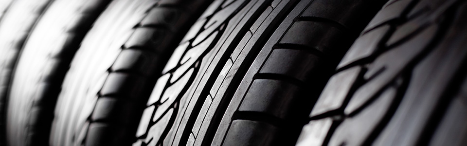 Close-up view of black tires stacked, showing textured tread patterns.
